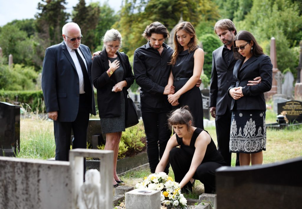 Trauernde Familie bei der Bestattung