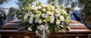 Weißes Blumengesteck auf Sarg