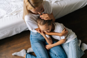 Mutter tröstet traurige kleine Tochter